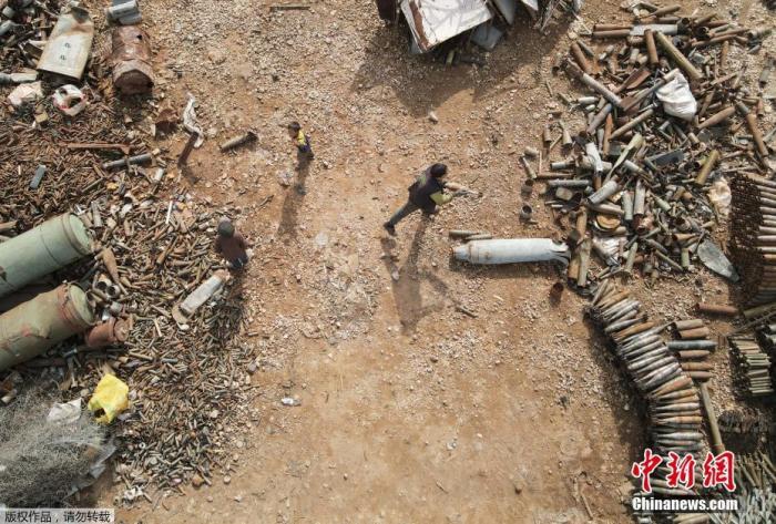 资料图：叙利亚伊德利卜省西北部一个金属废料场上，人们整理堆放的炮弹废料。