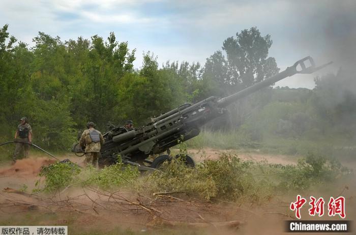 资料图：乌军士兵使用美国提供的M777榴弹炮向俄军阵地开火。